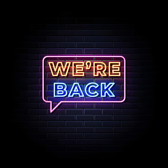 Neon sign "We're Back" against dark blue brick wall